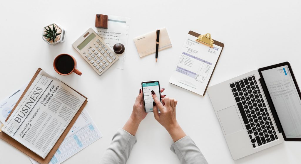 Recepcionista de oficina virtual utilizando su smartphone en un escritorio de trabajo
